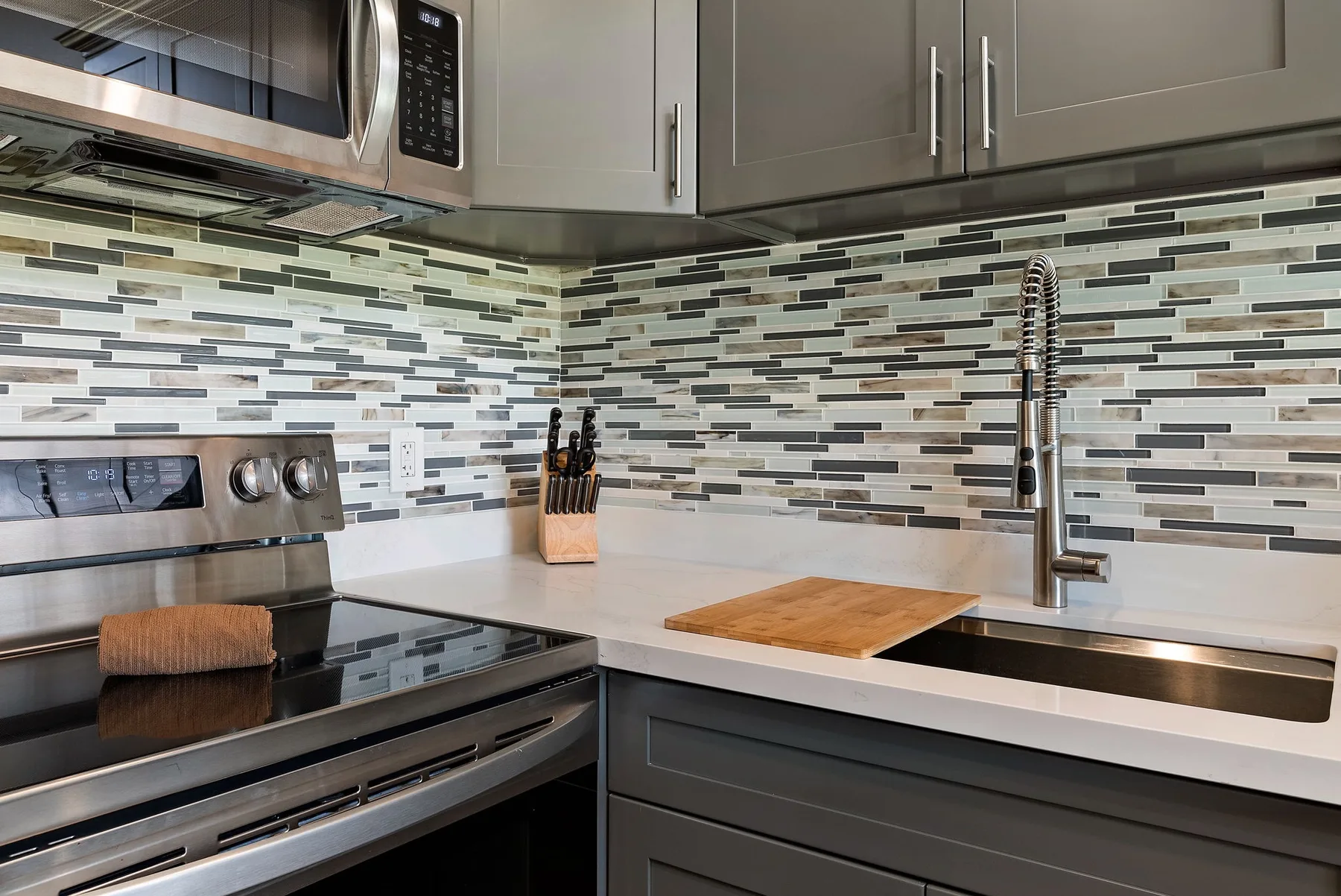 A modern kitchen with a built-in oven, countertop, and sink.