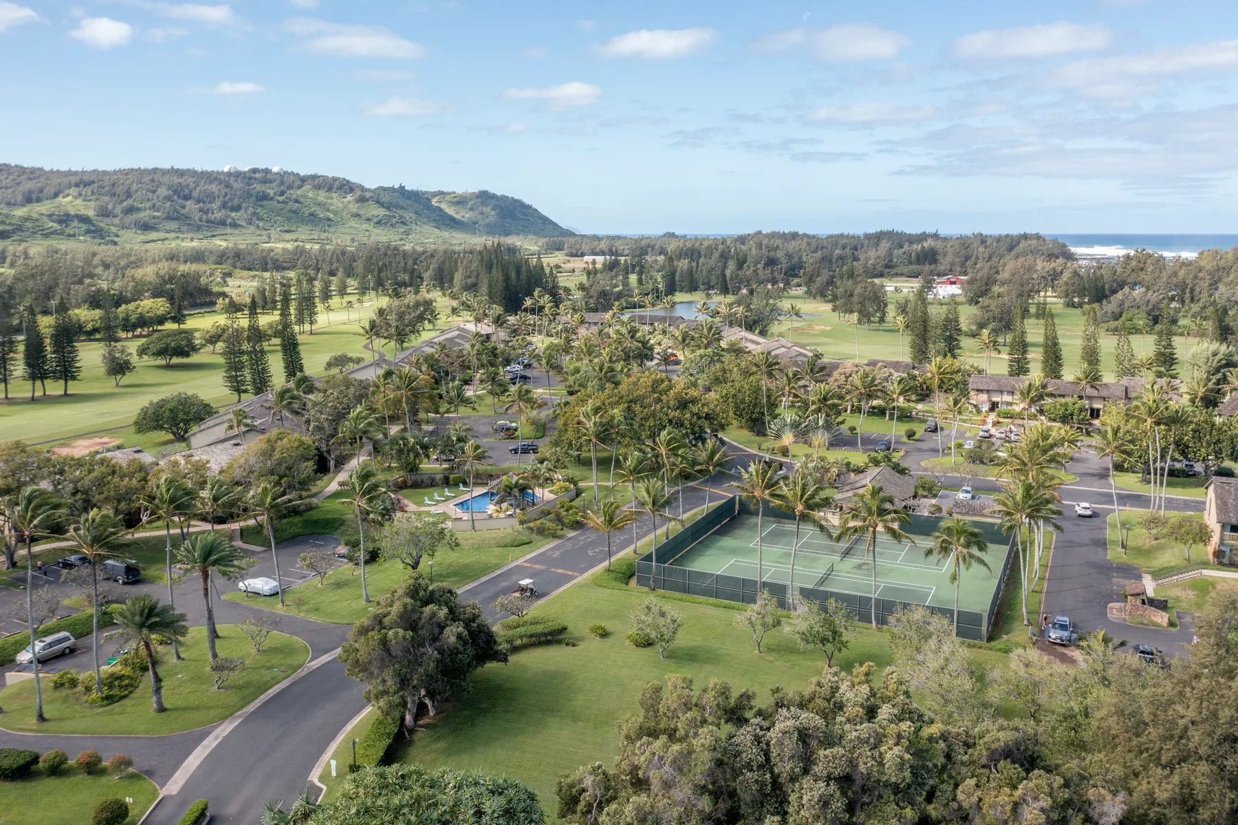 A landscaped resort grounds with tennis courts, pools, and winding paths.