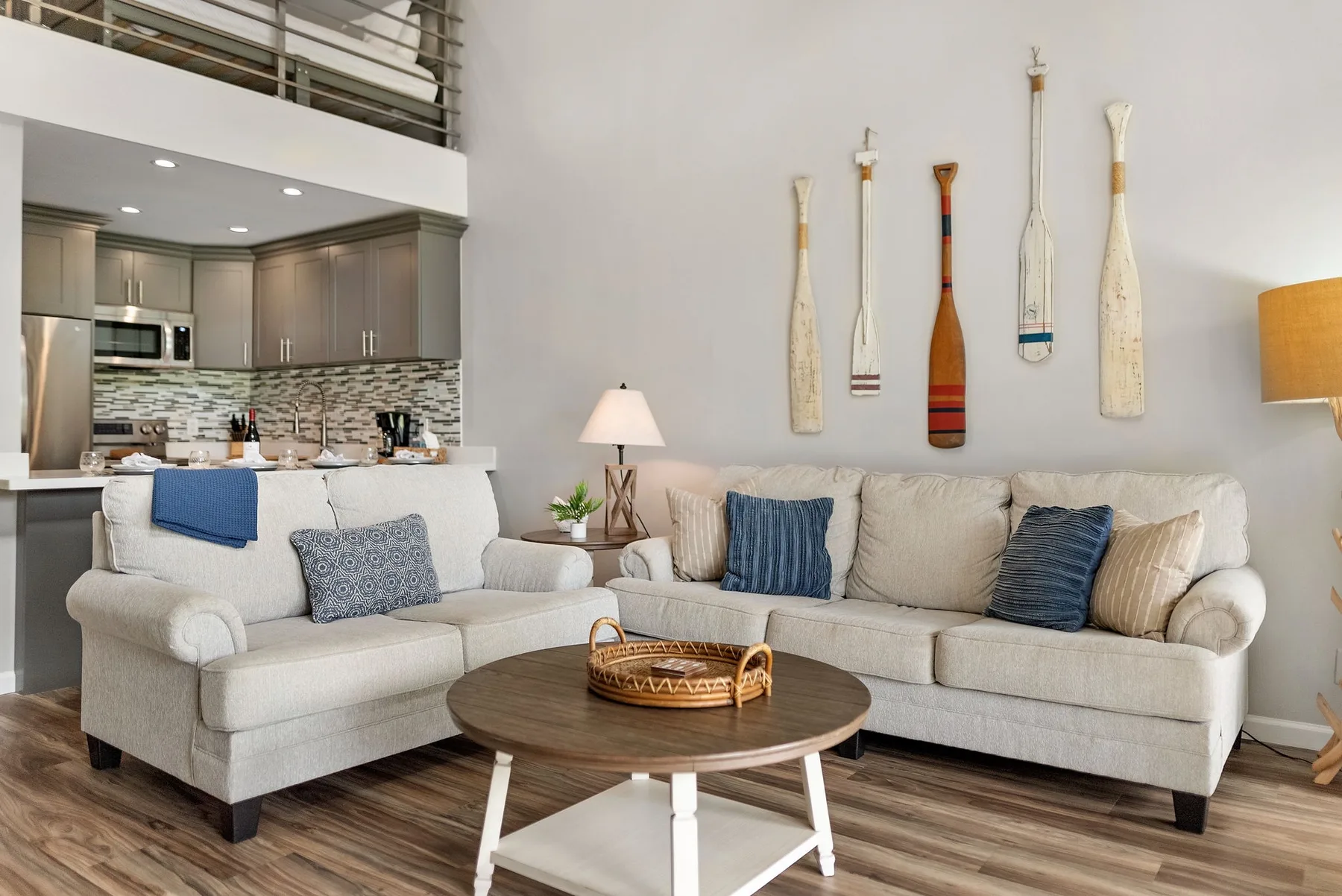 A bright living room with a sectional seating area and an open kitchen.