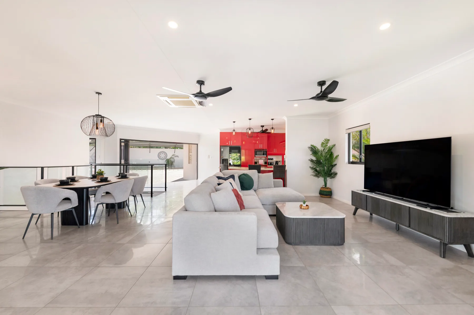 An open-plan living and dining area features seating, a coffee table, and a television.