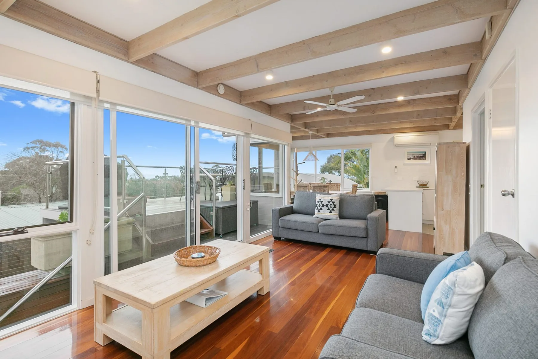 Living room with seating and large windows opening onto a deck.