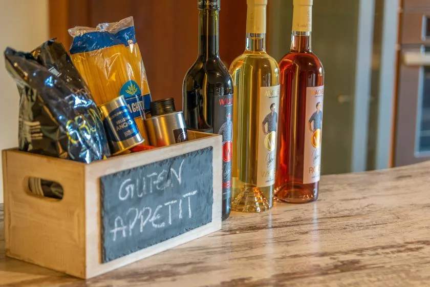 Una presentación sobre la encimera con aperitivos empaquetados, bebidas embotelladas y una pequeña pizarra.