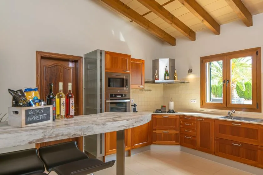 Una cocina luminosa con armarios de madera, una encimera y una ventana.
