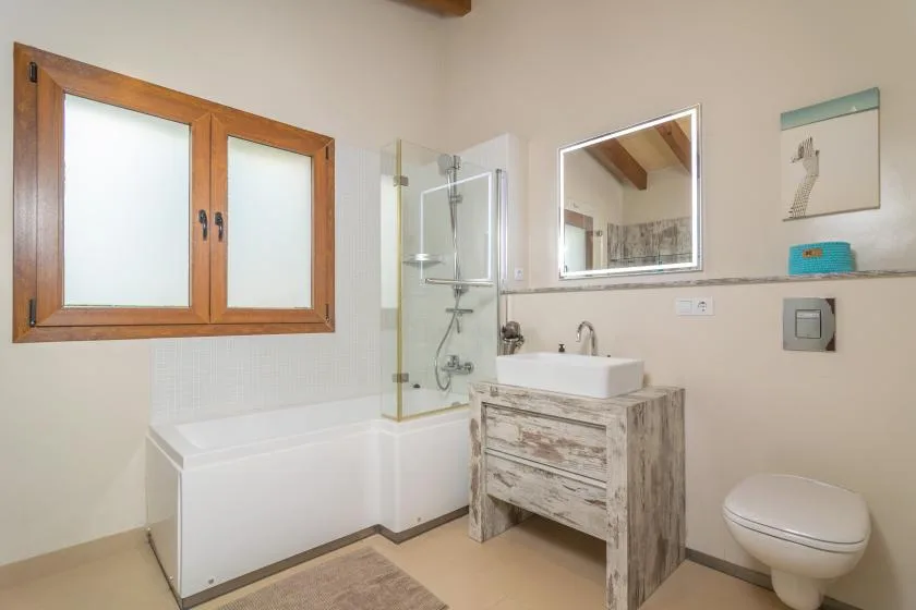 Un baño con bañera, mampara de ducha de vidrio y lavabo.