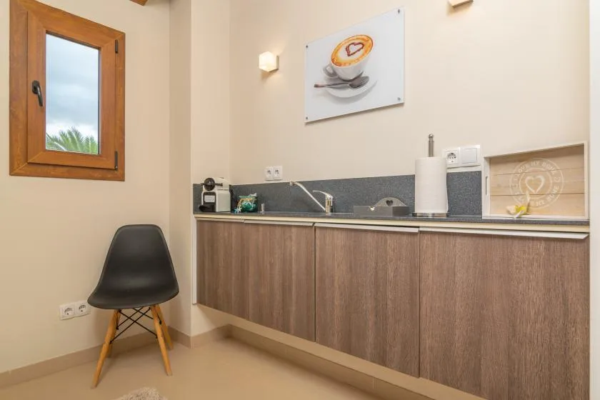 Una pequeña cocina con armarios de madera, un fregadero y una ventana.
