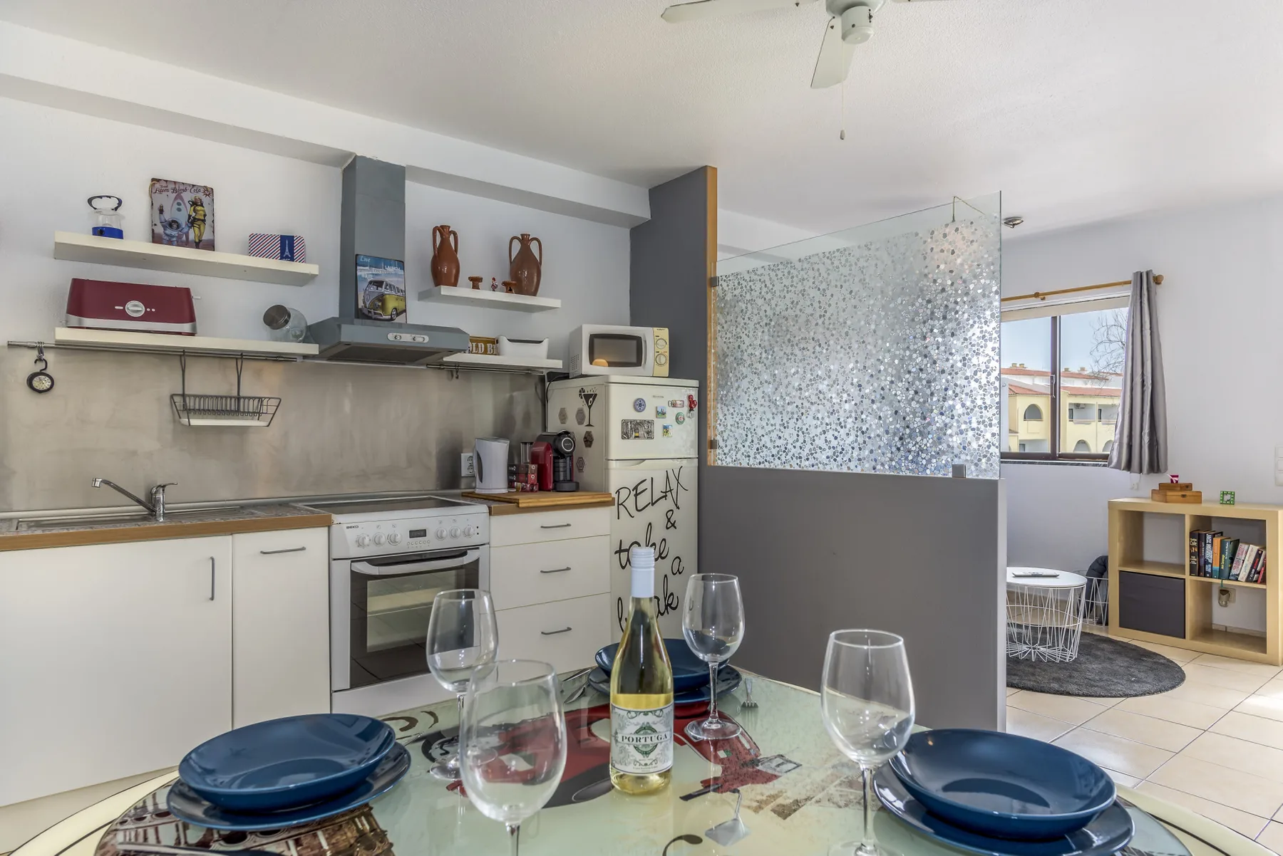 An open-plan kitchen and dining area with a table set for a meal.