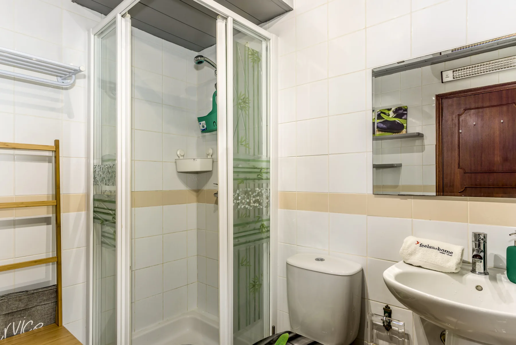A tiled bathroom with a shower, toilet, and sink.