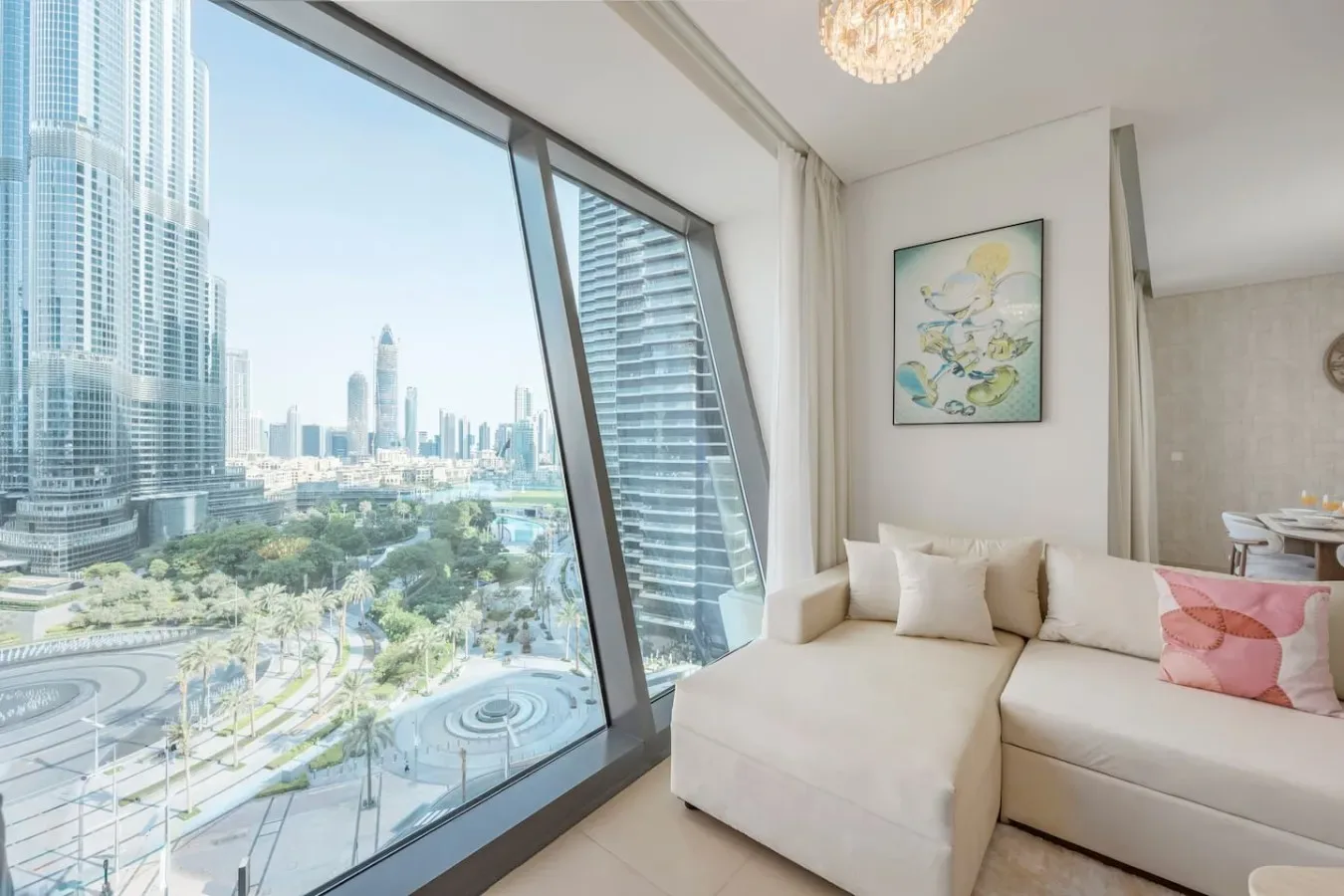 Una sala luminosa con una zona de asientos junto a grandes ventanales con vistas a la ciudad.