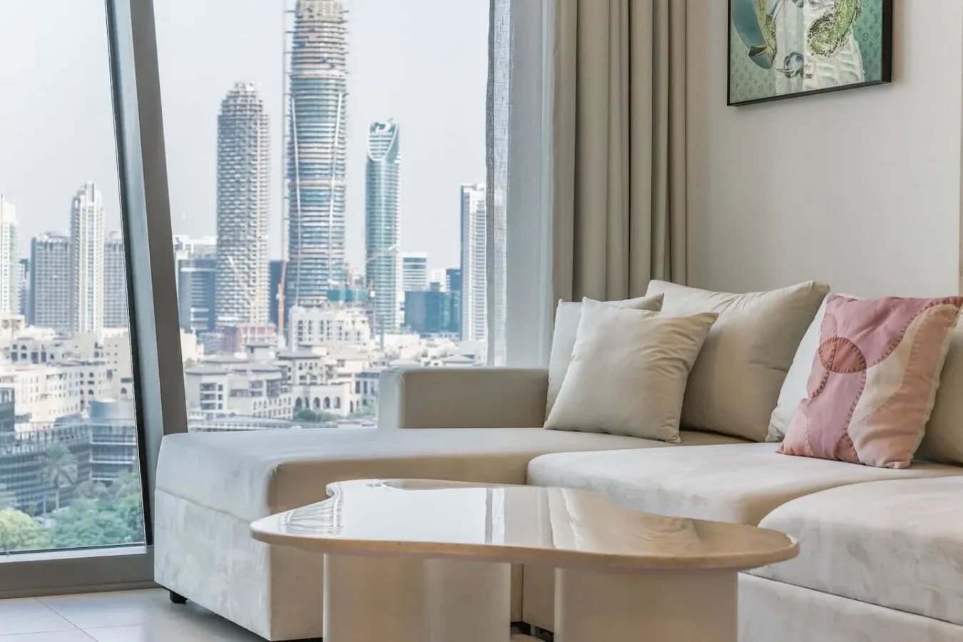 Una sala luminosa con asientos junto a grandes ventanales con vistas a edificios de la ciudad.