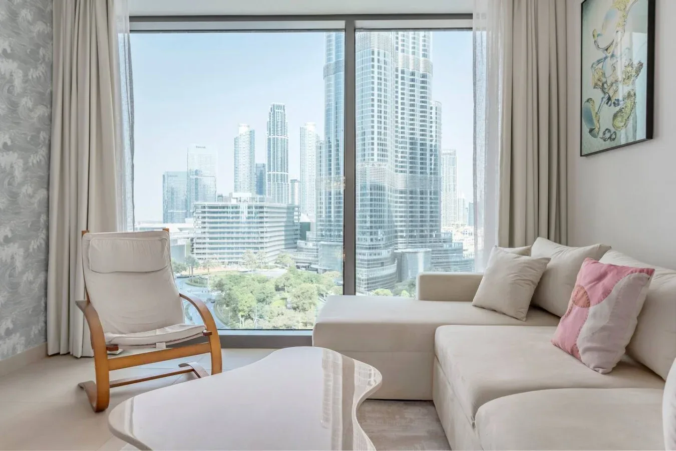Una sala de estar con asientos junto a una gran ventana con vistas a edificios de la ciudad.