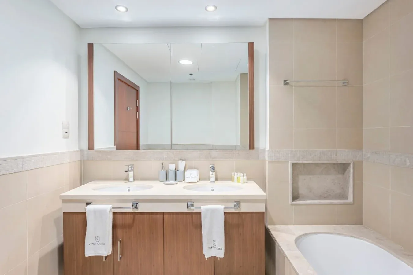 Un lavabo de baño con un espejo amplio y una bañera al lado.