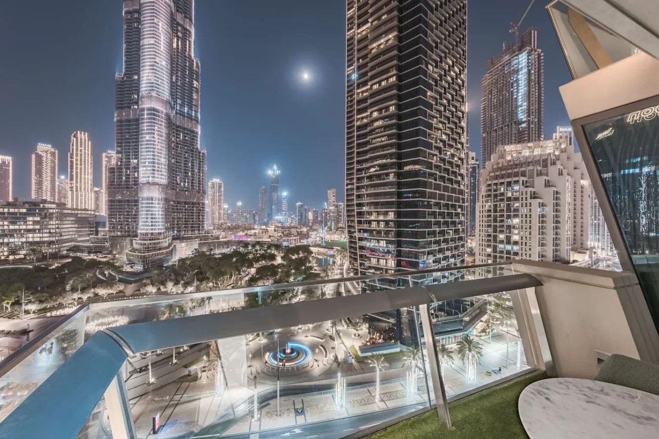 Un balcón da a un horizonte urbano iluminado por la noche.