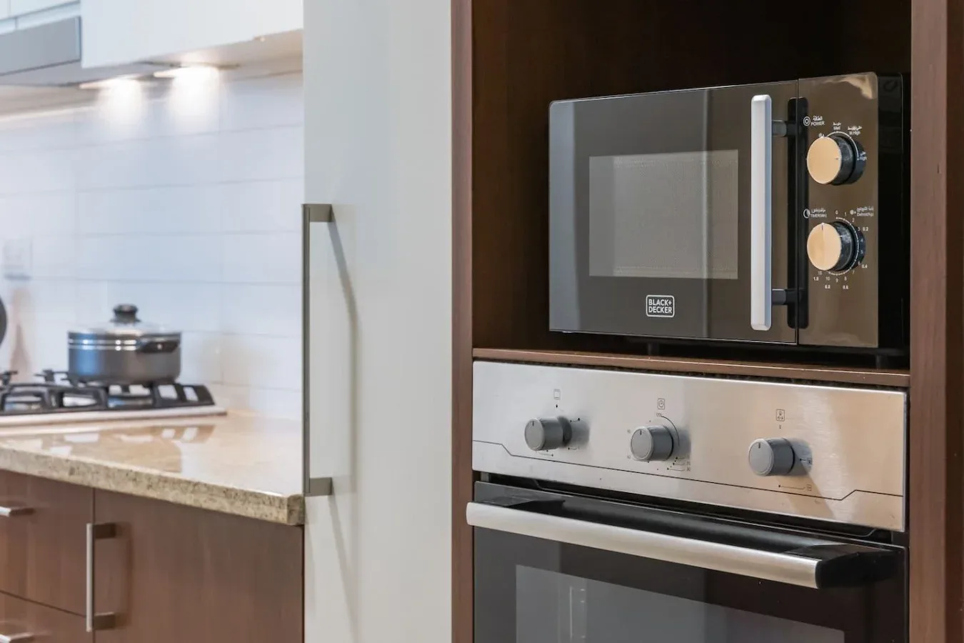 Una cocina moderna con microondas y horno empotrados junto a una placa de cocción.