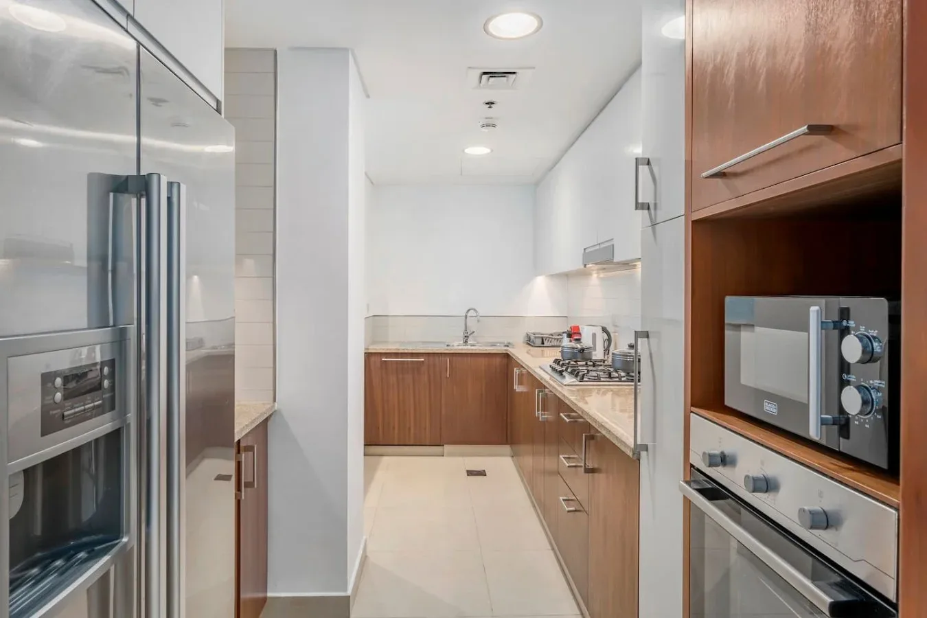 Una cocina moderna con gabinetes de madera, electrodomésticos de acero inoxidable y una zona de trabajo central.