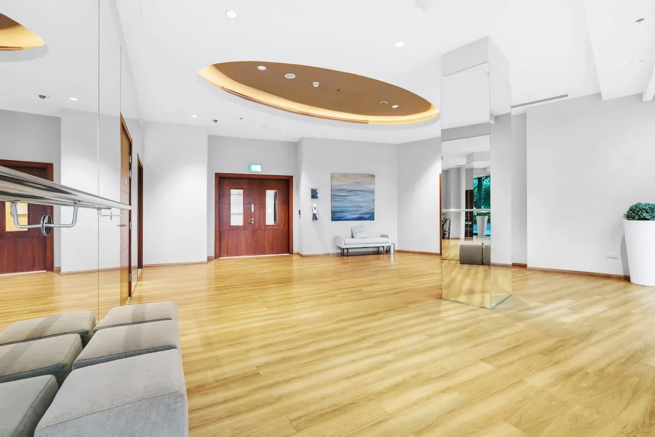 Una amplia sala interior con suelo de madera pulida y una zona de asientos.