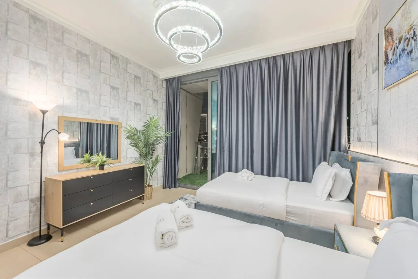Un dormitorio con dos camas, cortinas grises y una cómoda junto a la pared.