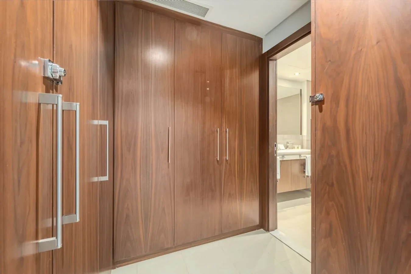 Una habitación revestida de madera con armarios empotrados y una puerta abierta a un baño.