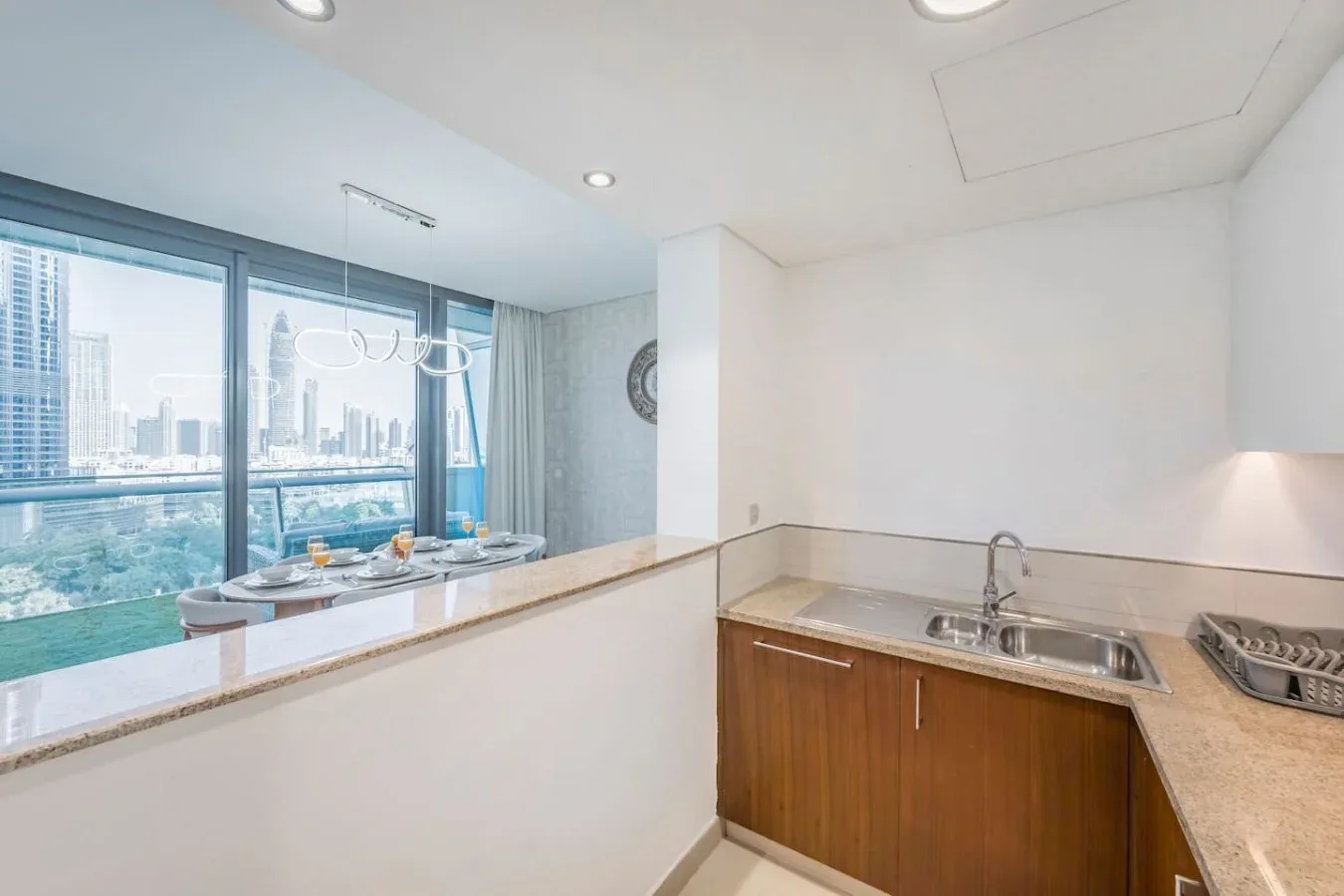 Una cocina luminosa con fregadero y grandes ventanas con vistas a la ciudad.