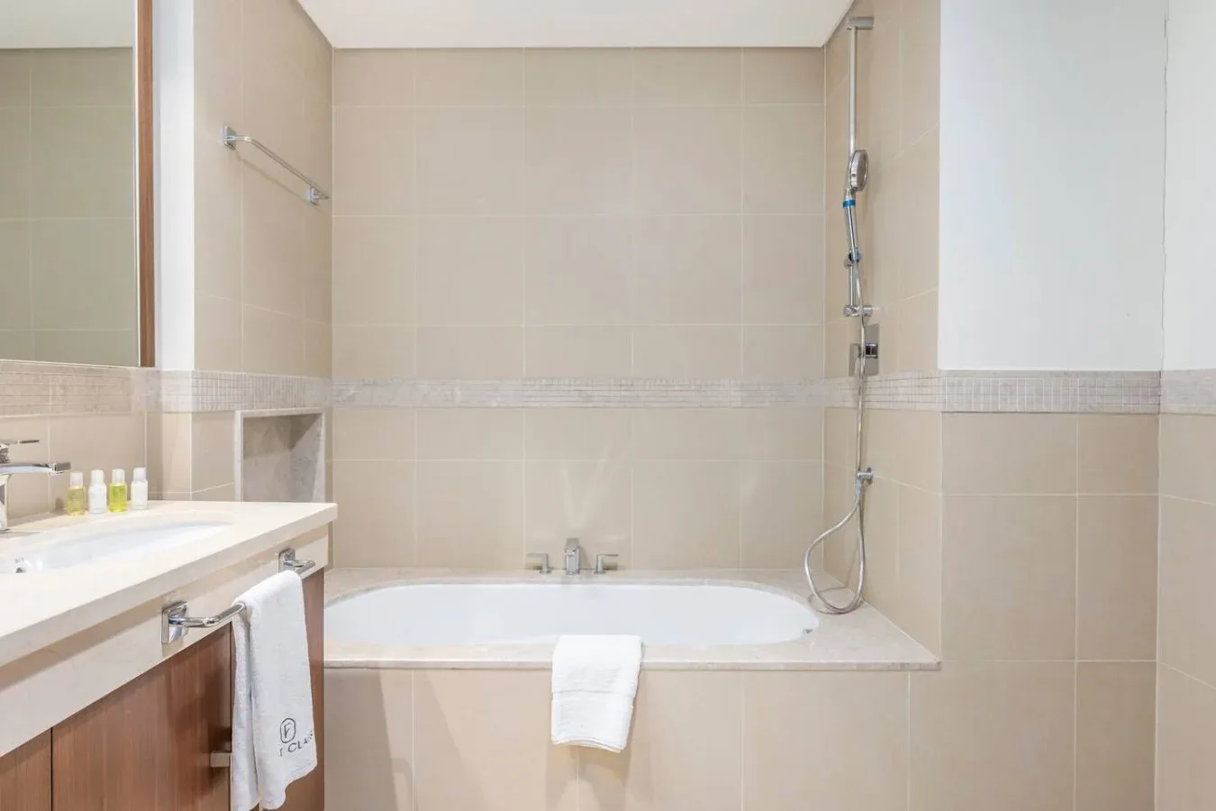 Un baño alicatado con bañera, ducha y lavabo.