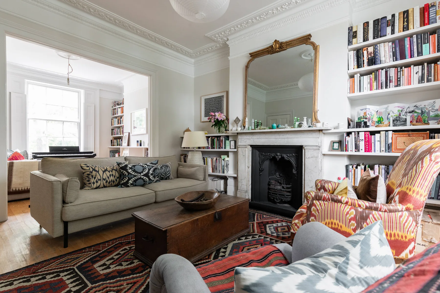 A living room with seating, a fireplace, bookshelves, and a coffee table.