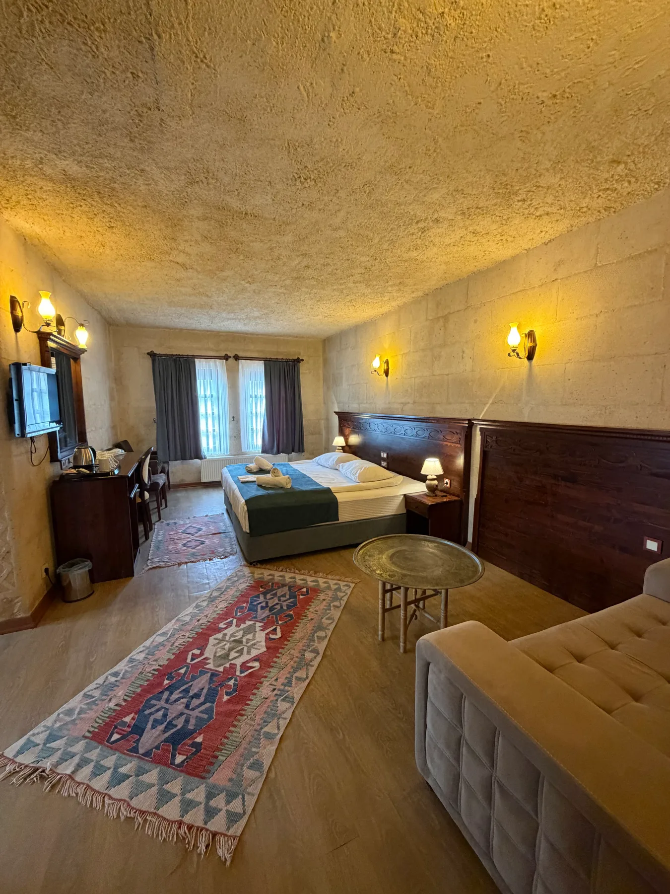La cama y la amplia zona de estar en una habitación con suelo de madera
