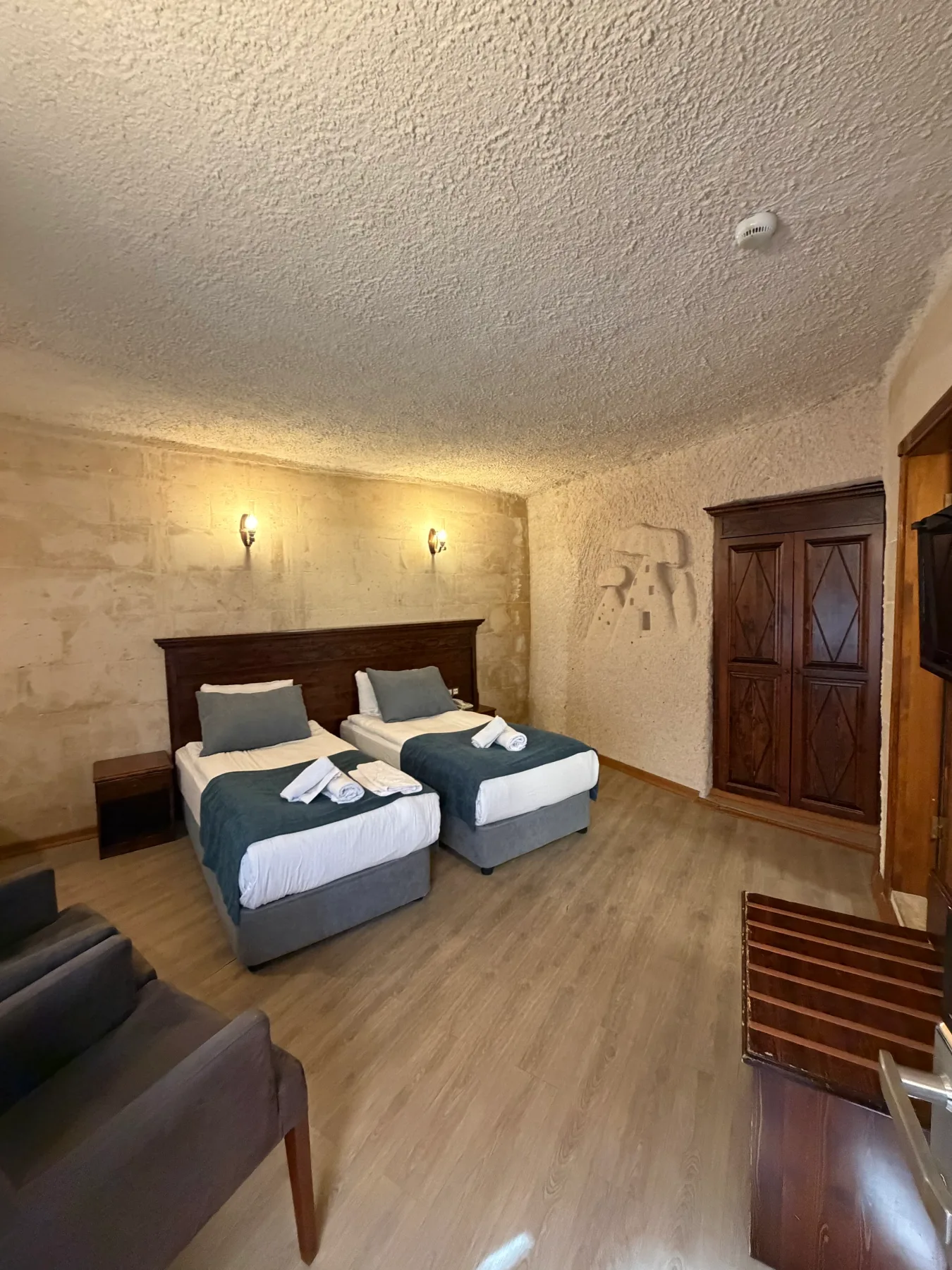 Dos camas individuales y una zona de estar en una habitación con suelo de madera