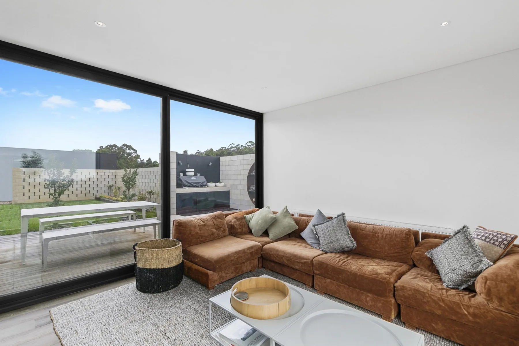A bright living room with sectional seating beside large glass doors.