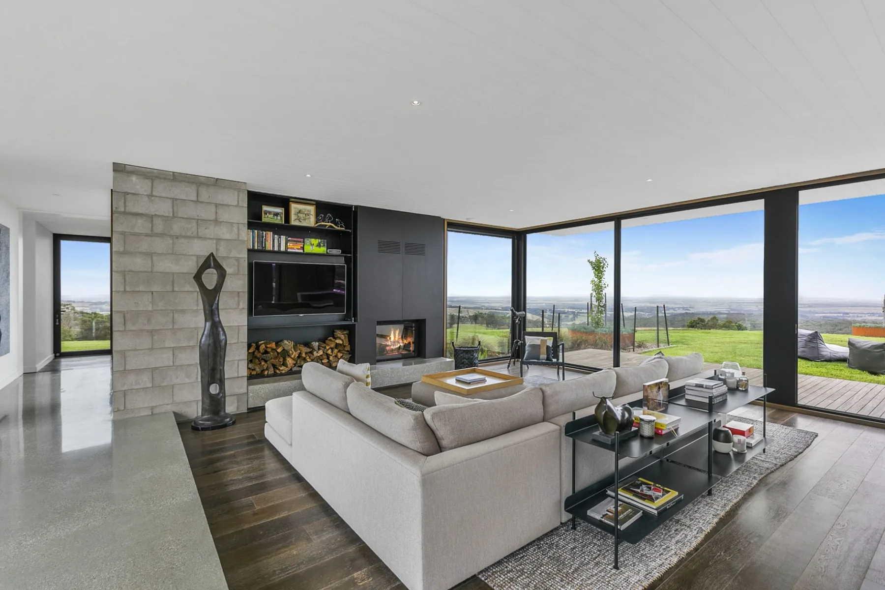A modern living room with a sectional seating area and large windows.