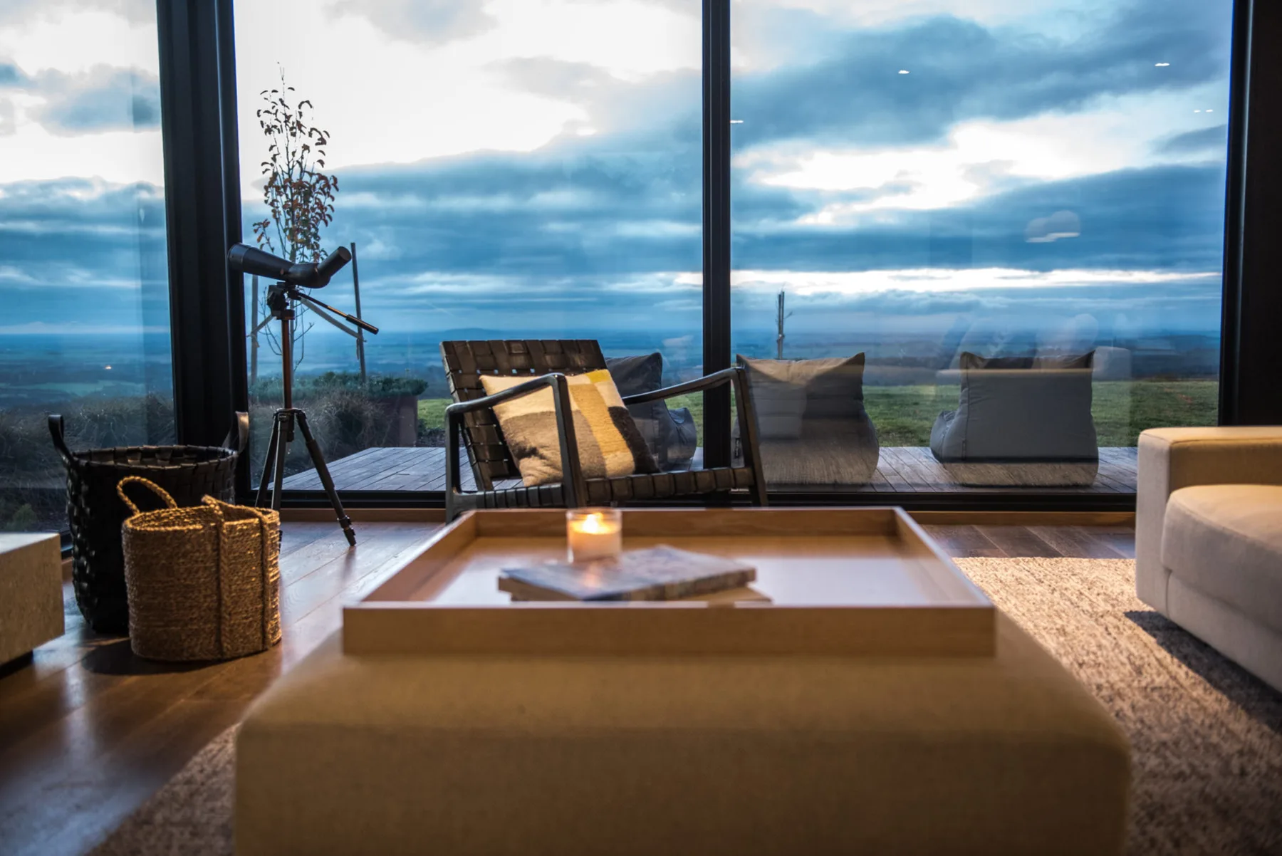 A living room with seating and a large window overlooking the landscape.