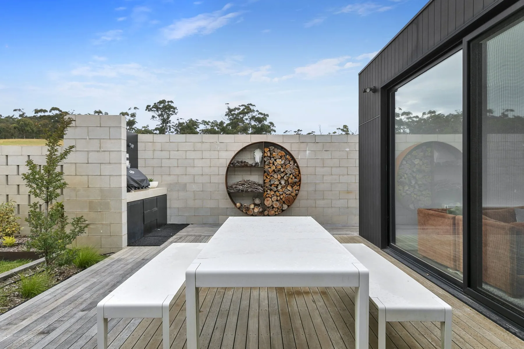 An outdoor dining area with a white table beside a modern building.