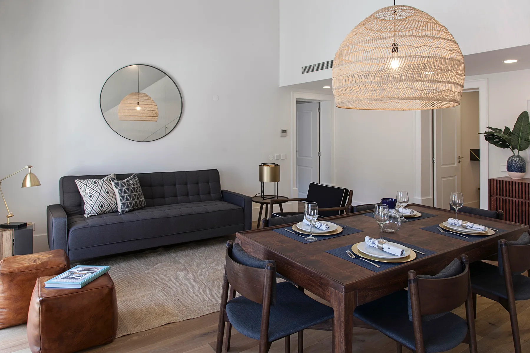 A living and dining area with a dark sofa and a wooden dining table.