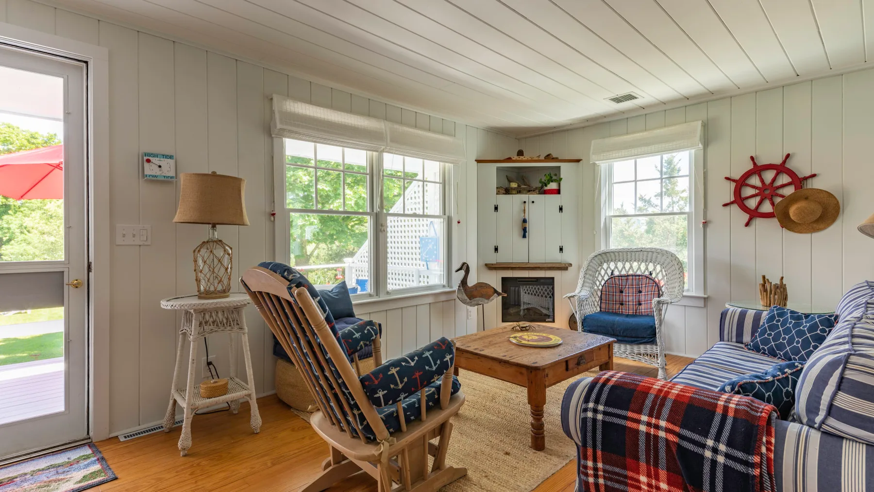 A bright living room with patterned seating around a wooden coffee table.