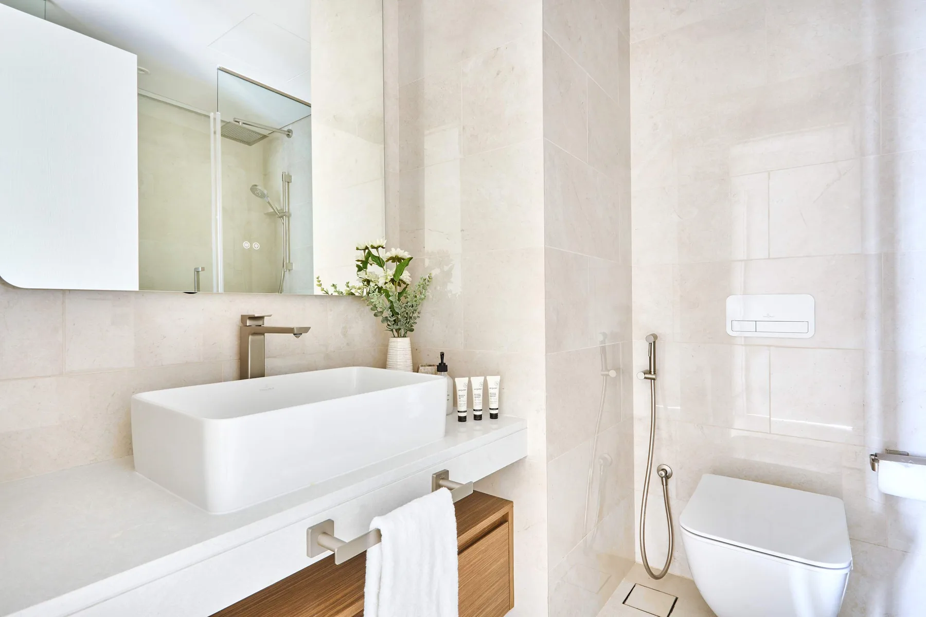 Un baño luminoso con una bañera blanca y un inodoro junto a una ducha de mano.