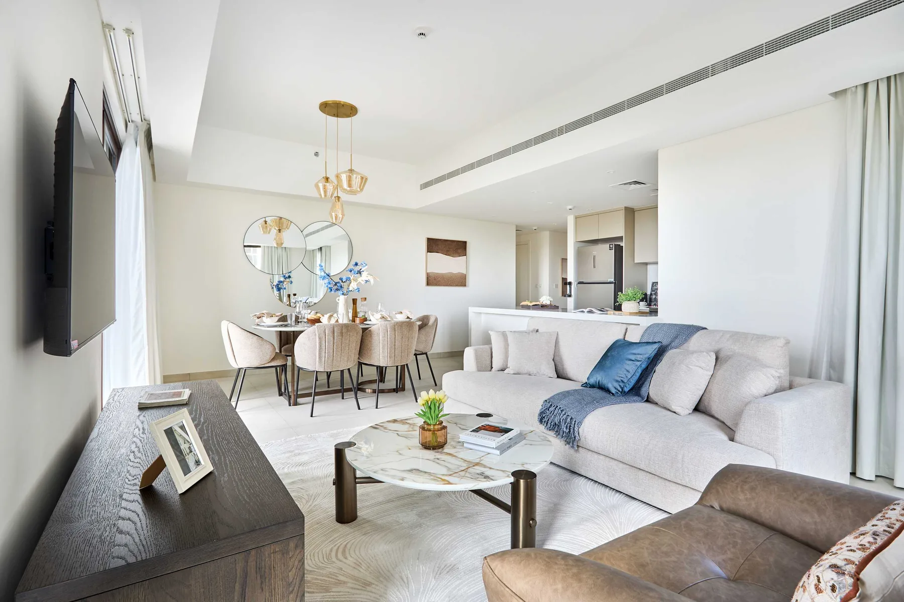 Luminoso espacio de sala y comedor con sofá, mesa de centro y mesa de comedor.