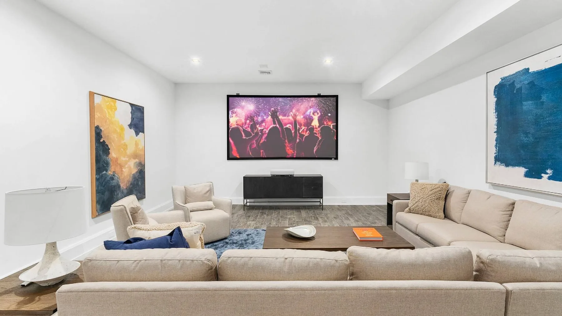Una sala de estar con asientos alrededor de una mesa de centro y un televisor.