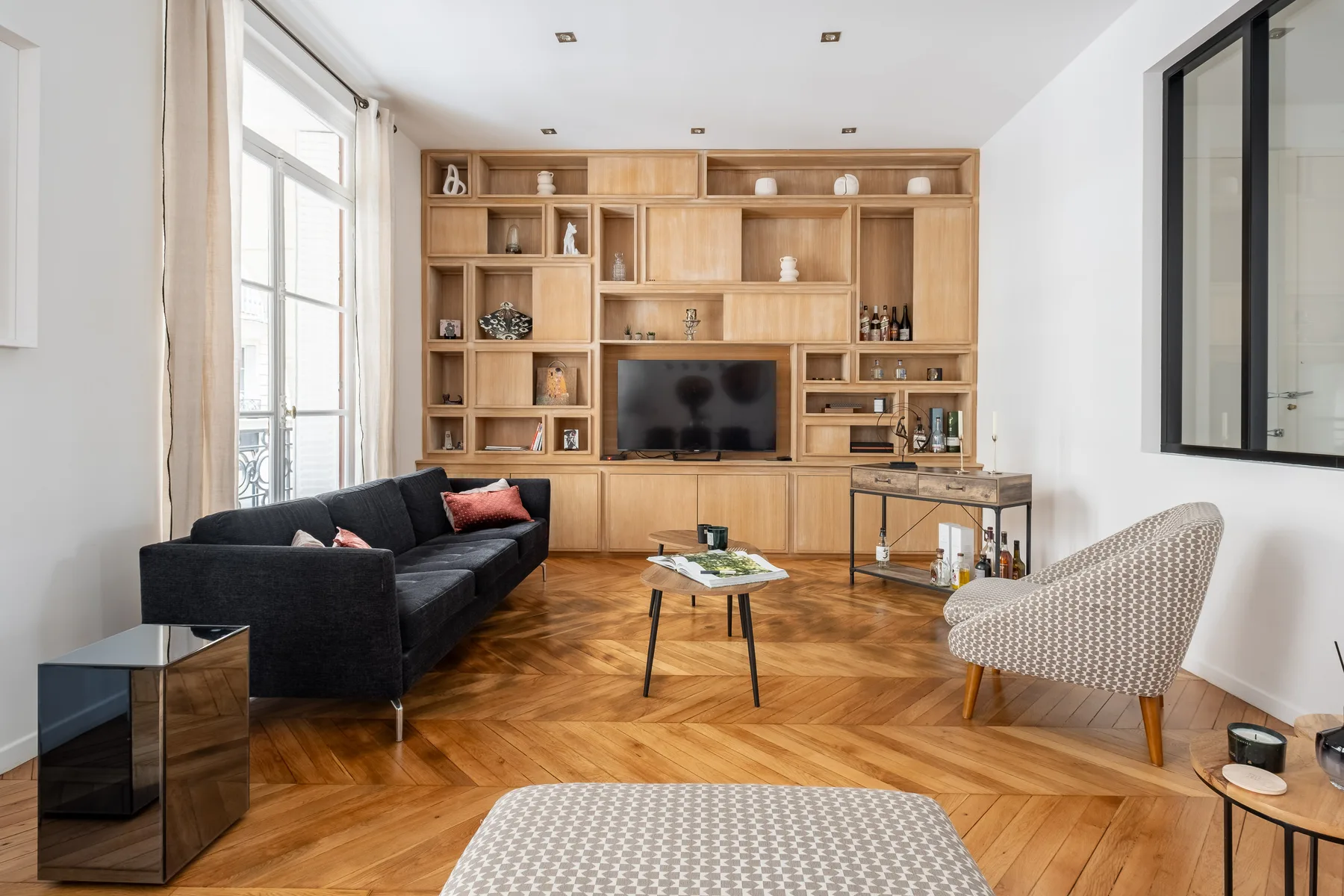 Una sala de estar con un televisor integrado en una estantería de madera.