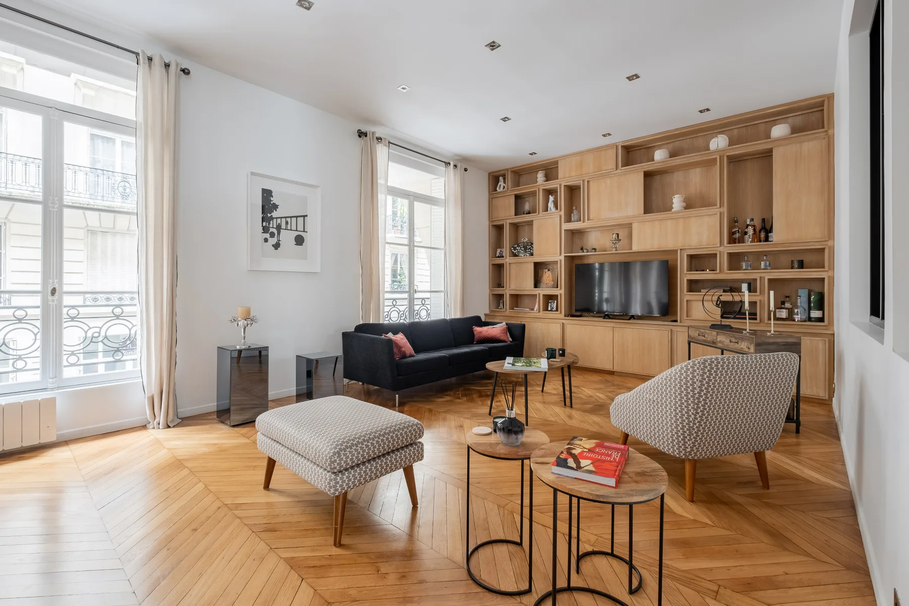 Una luminosa sala de estar con estanterías de madera empotradas y una zona de estar.