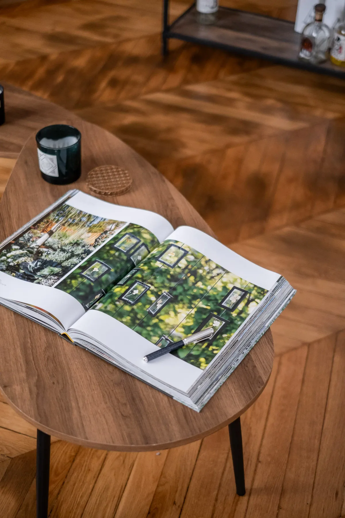 Un libro abierto está sobre una mesa de madera junto a un frasco pequeño.
