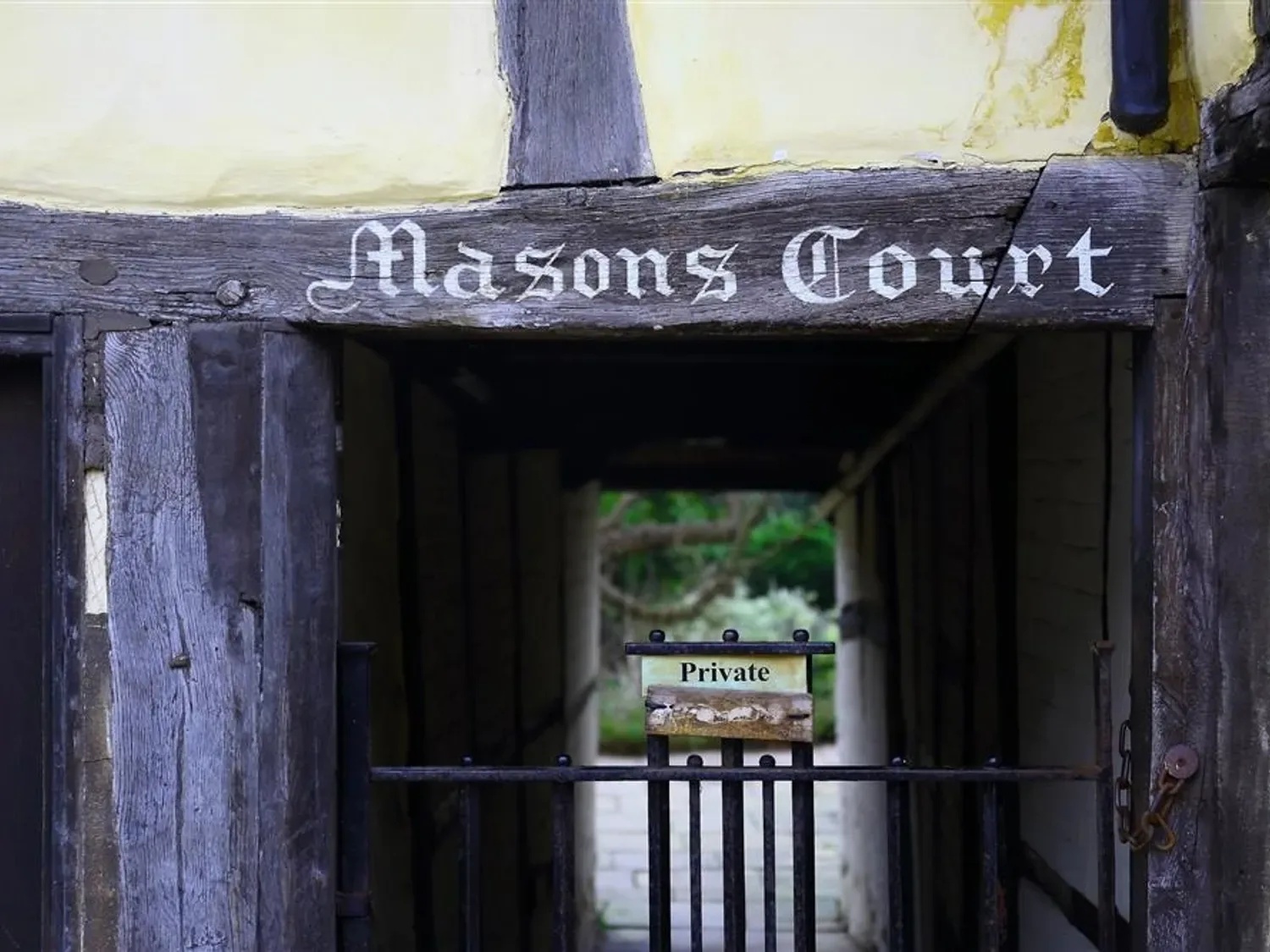 A timber-framed entrance bears a Masons Court sign above a metal gate.