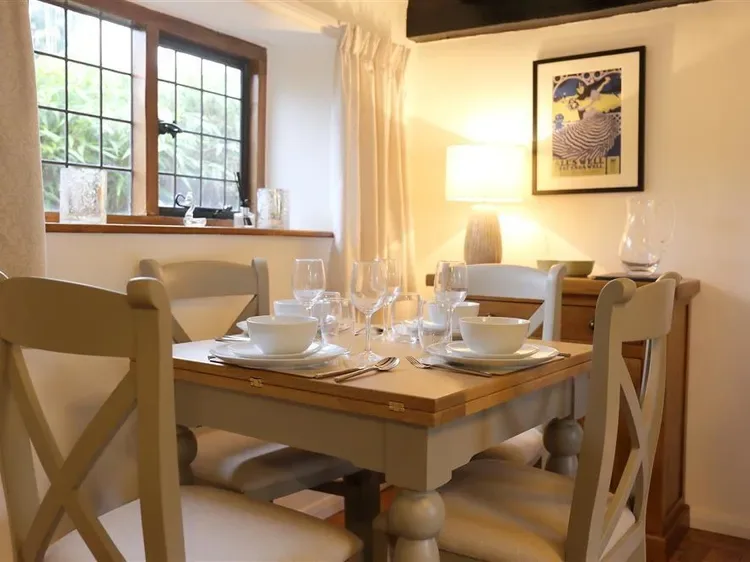 A dining area with a set table beside a large window.