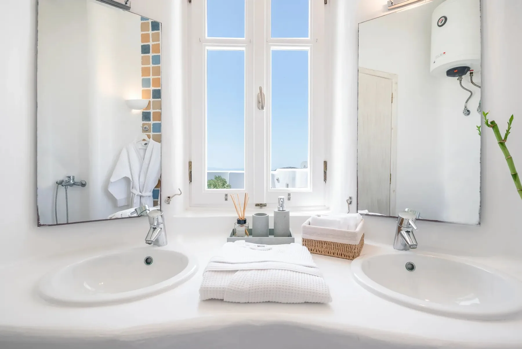 Un baño luminoso con dos lavabos y una ventana grande.