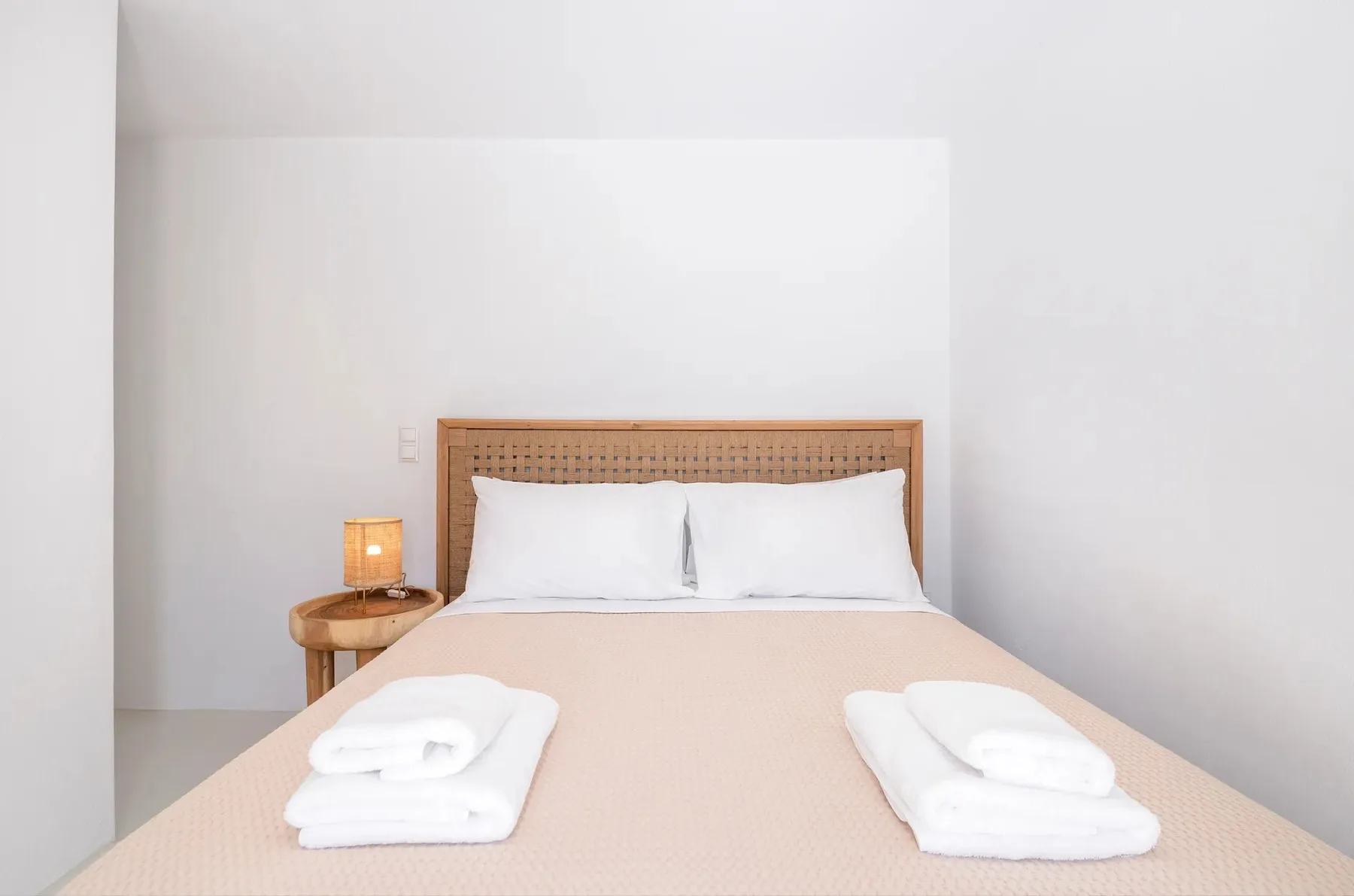 Un dormitorio con una cama bien hecha y toallas dobladas.