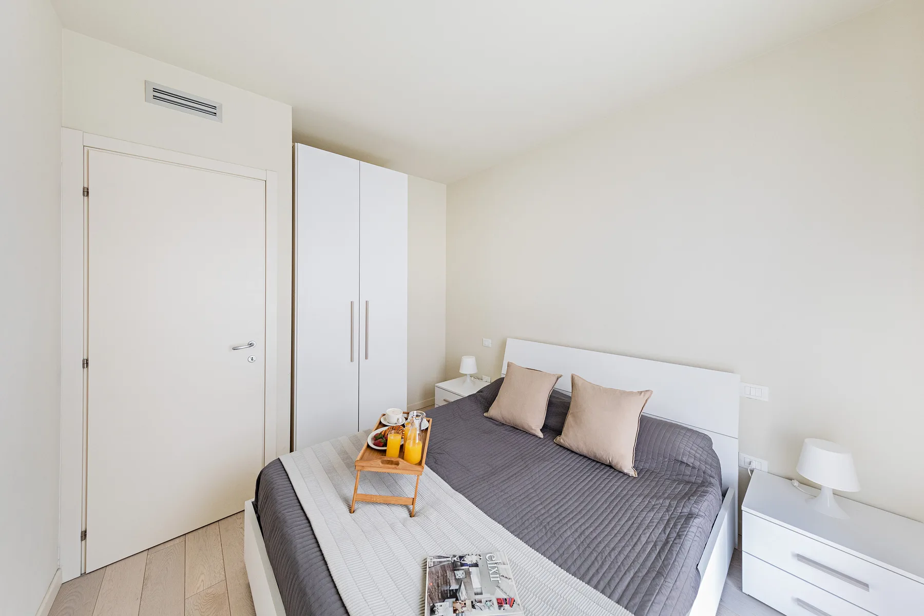 A bright bedroom with a double bed and bedside storage.