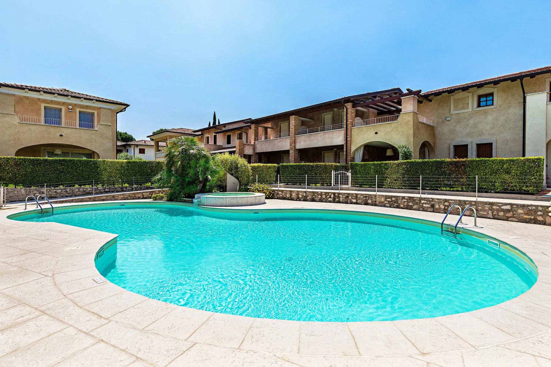 An outdoor swimming pool sits in front of a row of residential buildings.