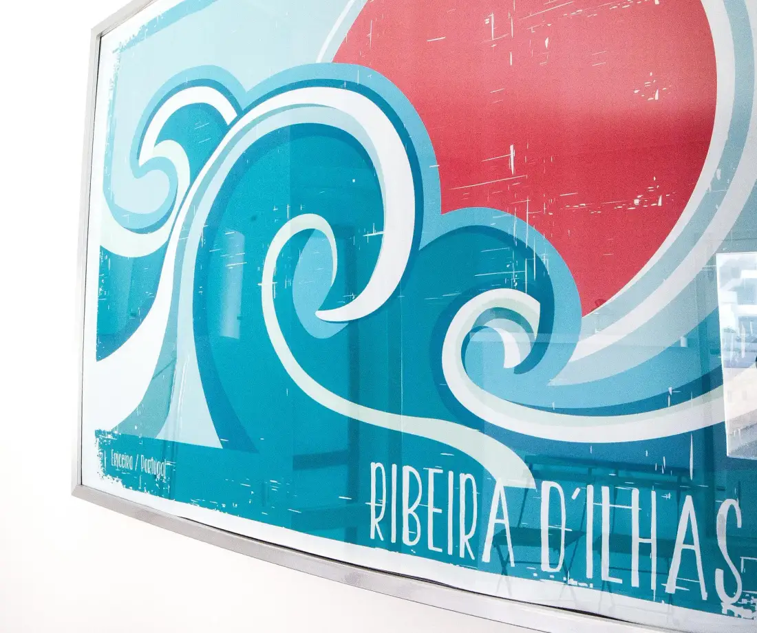 A framed surf poster with stylized blue waves and the text “Ribeira d’Ilhas.”