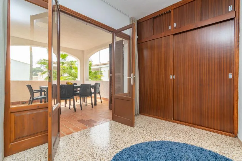 A room opens onto a covered dining area with a table and chairs.