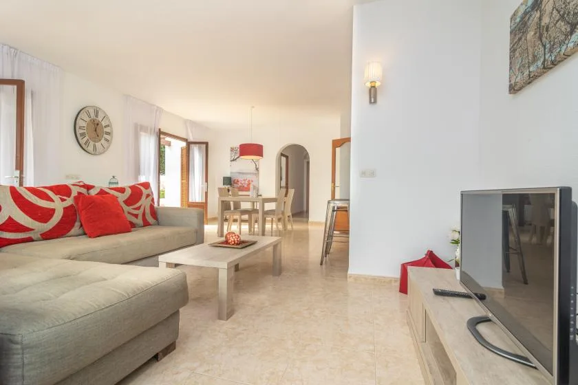 A bright living room with seating, a coffee table, and a dining area.