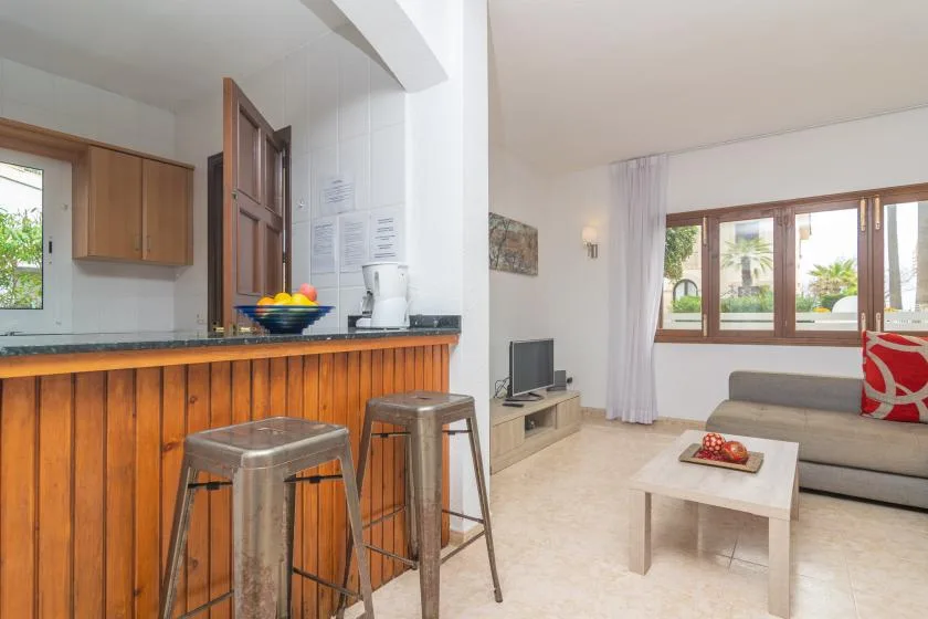 An open-plan living room and kitchen with a breakfast bar and seating.