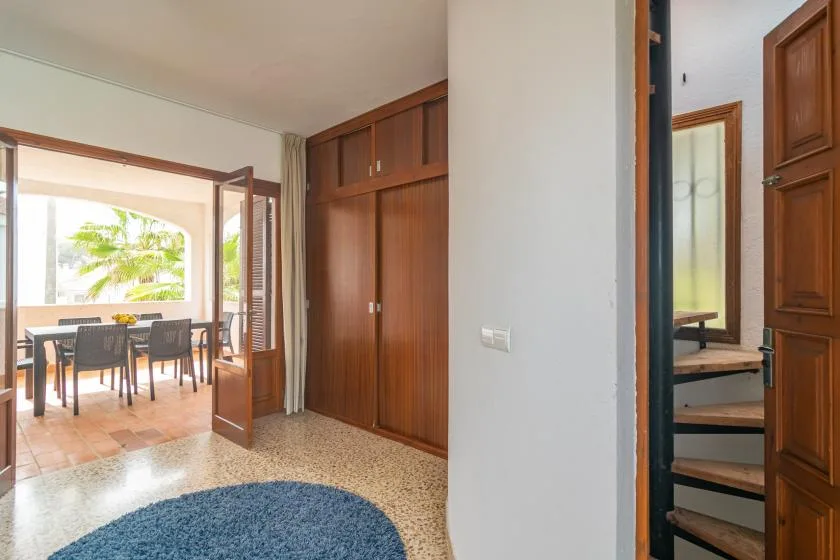 An interior hallway opens to a dining area beside a staircase.
