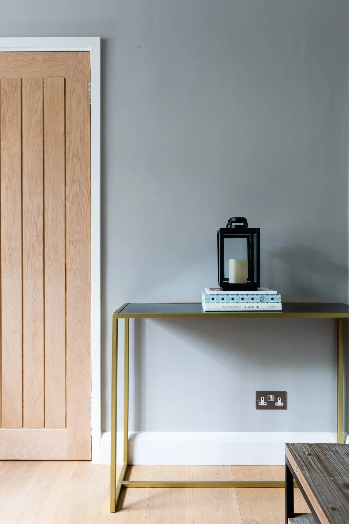 A simple hallway with a wooden door and a narrow console table.